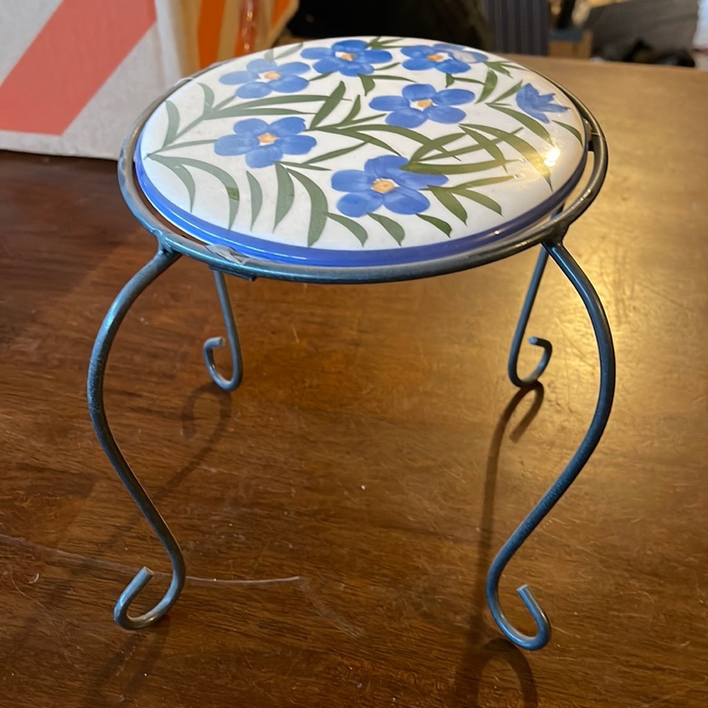 Two iron stands with blue flowered tops